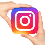 Hands hold Instagram icon printed on paper